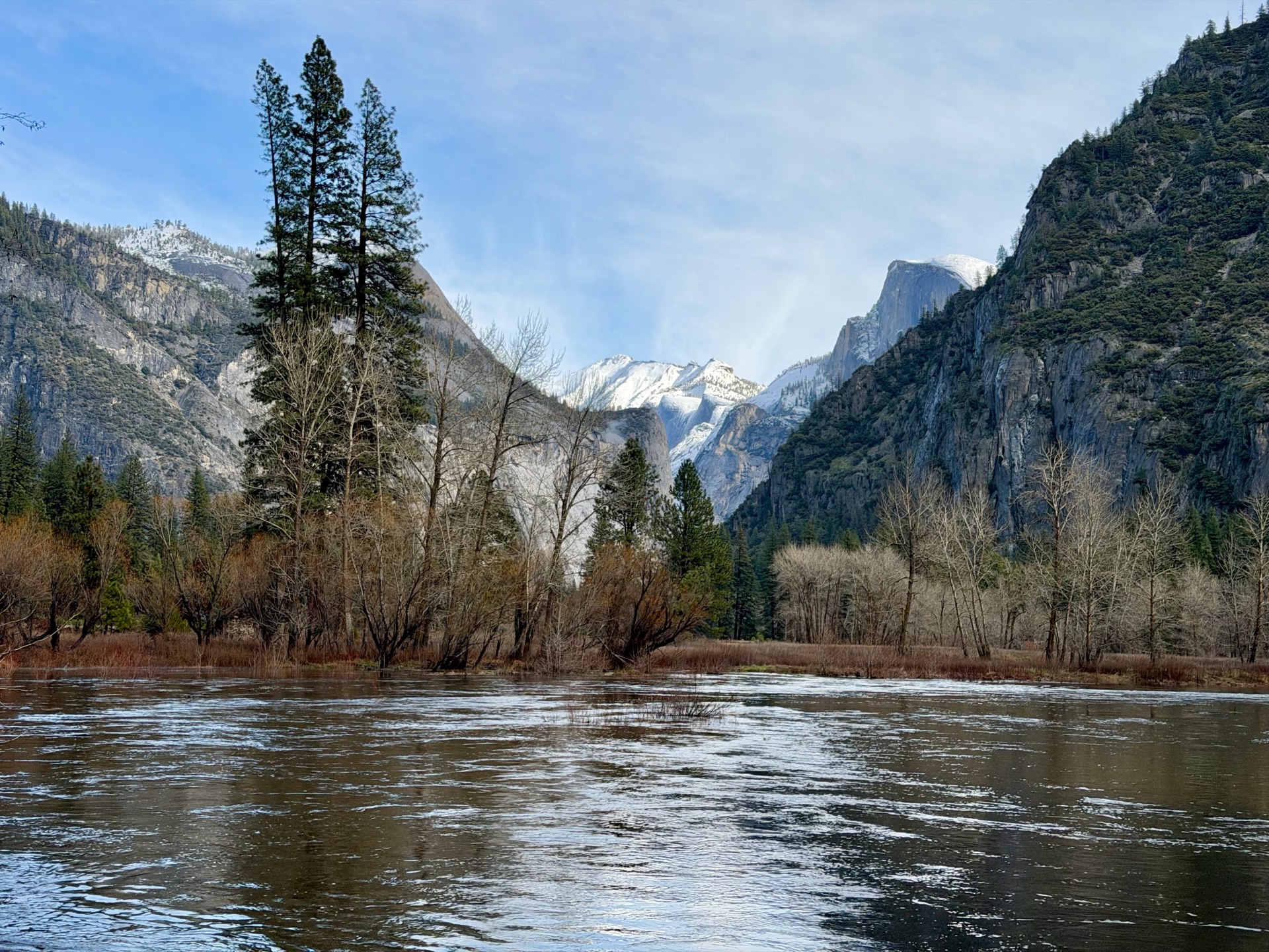 A swollen Merced River provides a backdrop for Half Dome and Clouds Rest.